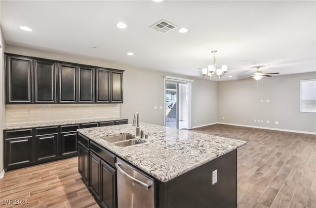 kitchen with stainless steel dishwasher, light hardwood / wood-style floors, a center island with sink, and sink