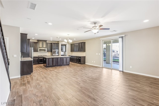 unfurnished living room featuring light hardwood / wood-style floors and ceiling fan with notable chandelier