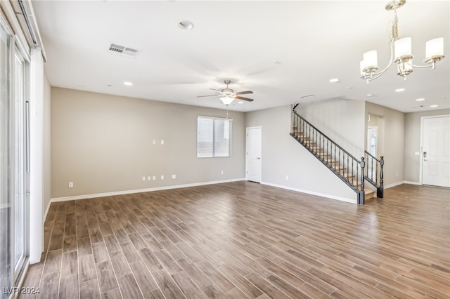 unfurnished living room with wood-type flooring and ceiling fan with notable chandelier