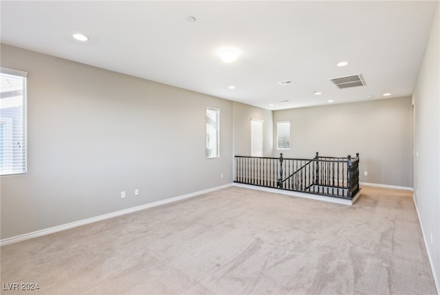 unfurnished room featuring light colored carpet