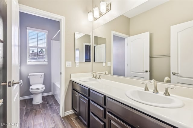 full bathroom with hardwood / wood-style flooring, vanity, toilet, and shower / bathtub combination