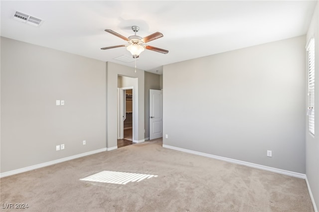 spare room featuring ceiling fan and light colored carpet