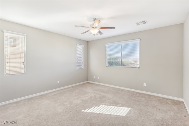 spare room featuring ceiling fan and light carpet