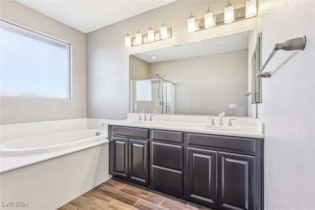 bathroom featuring vanity, hardwood / wood-style flooring, and plus walk in shower