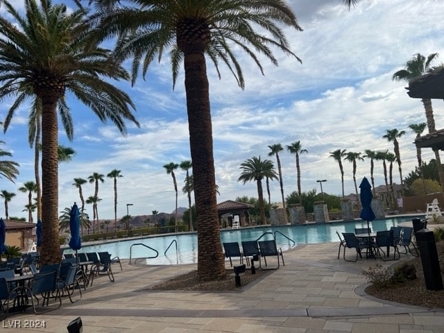 view of pool with a water view and a patio area