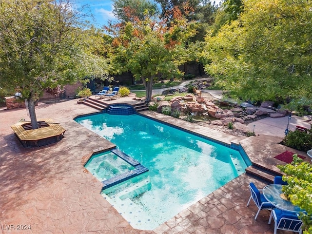 view of pool featuring a patio and an in ground hot tub