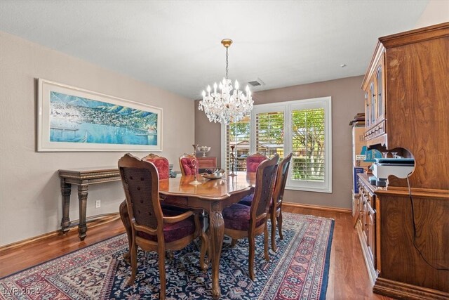 dining space featuring hardwood / wood-style flooring and a notable chandelier