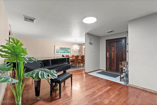 miscellaneous room featuring hardwood / wood-style flooring and a notable chandelier