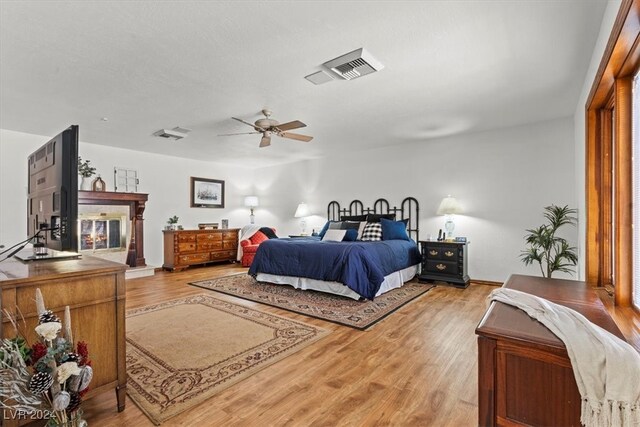 bedroom with light hardwood / wood-style floors and ceiling fan