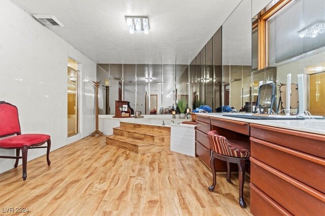 bathroom featuring plus walk in shower, vanity, and wood-type flooring