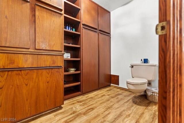 interior space with hardwood / wood-style flooring and toilet