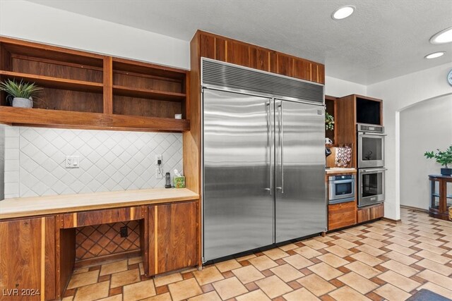 kitchen featuring stainless steel appliances and decorative backsplash