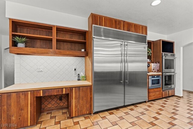 kitchen featuring stainless steel appliances and decorative backsplash