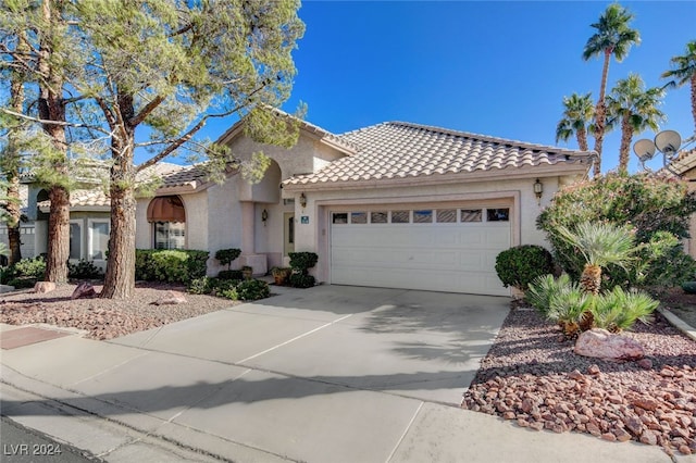 mediterranean / spanish-style home with a garage