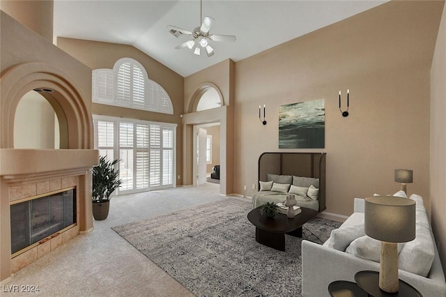 living room featuring a tile fireplace, ceiling fan, light colored carpet, and lofted ceiling