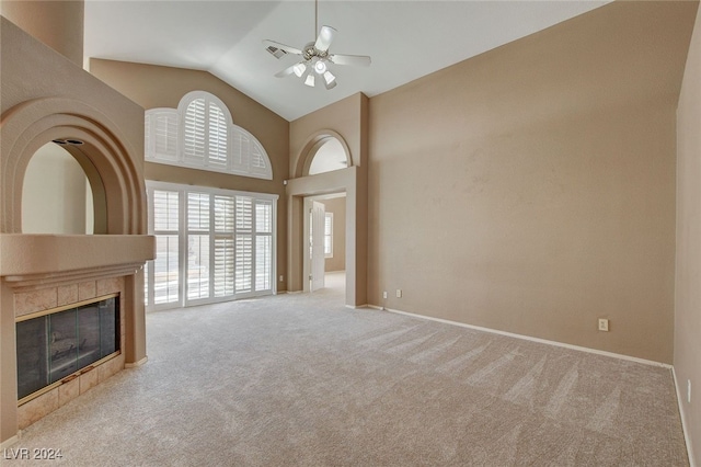 unfurnished living room featuring ceiling fan, lofted ceiling, light carpet, and a tile fireplace