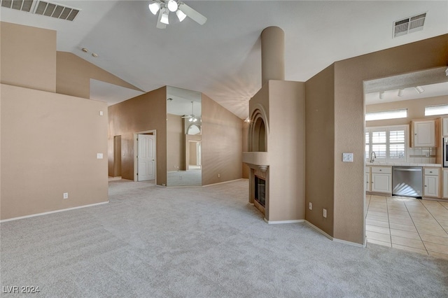 unfurnished living room with ceiling fan, light colored carpet, and vaulted ceiling