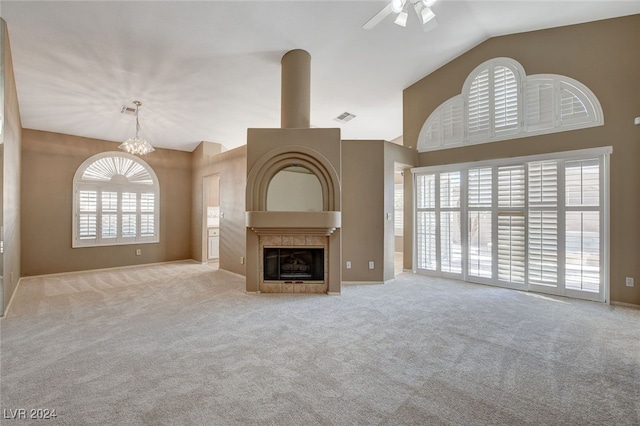 unfurnished living room featuring lofted ceiling, light colored carpet, and ceiling fan with notable chandelier