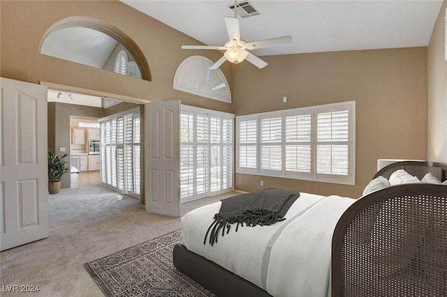 carpeted bedroom featuring multiple windows, ceiling fan, and high vaulted ceiling