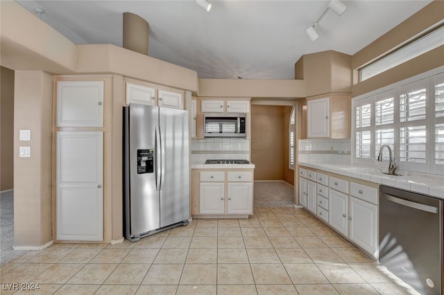 kitchen with tile countertops, white cabinetry, appliances with stainless steel finishes, and tasteful backsplash