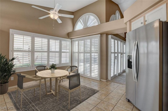 tiled dining area with ceiling fan and vaulted ceiling