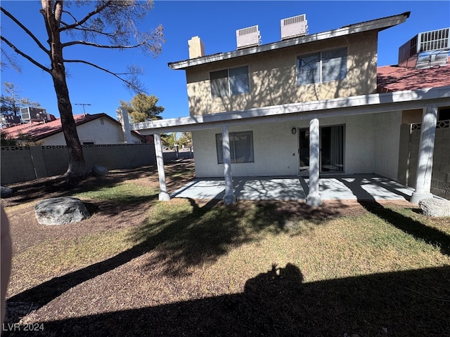 rear view of property featuring a patio area and a yard