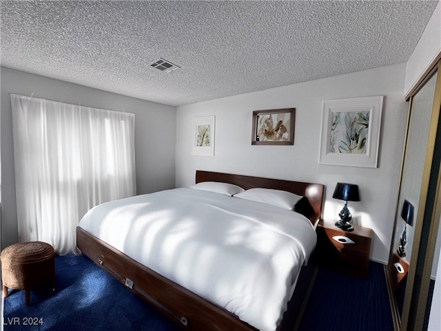 carpeted bedroom featuring a textured ceiling and a closet