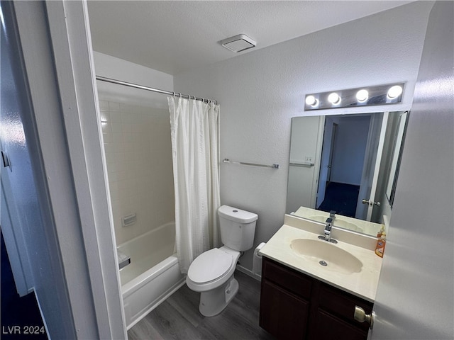 full bathroom featuring wood-type flooring, toilet, a textured ceiling, vanity, and shower / bath combination with curtain