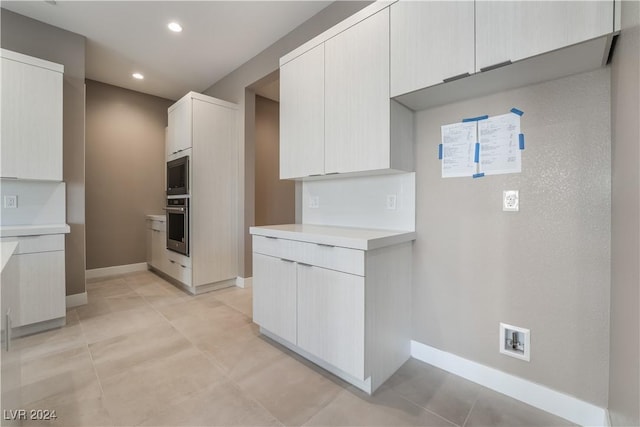 kitchen featuring white cabinets, oven, and built in microwave