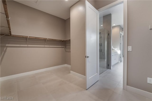 walk in closet with light tile patterned floors