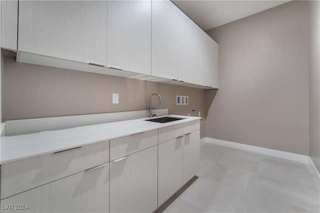 laundry area featuring hookup for a washing machine, sink, and cabinets