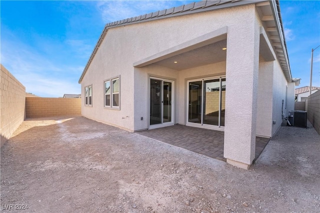 rear view of property featuring cooling unit and a patio