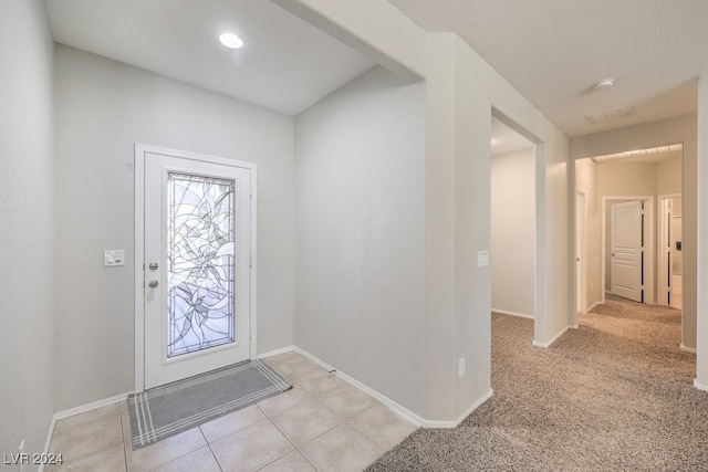 foyer entrance featuring light colored carpet