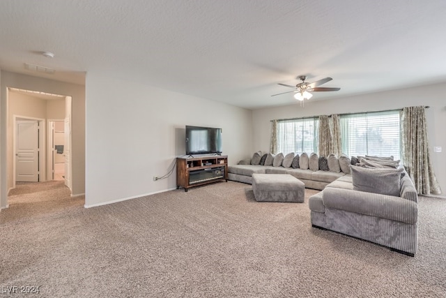 living room featuring ceiling fan, a textured ceiling, and carpet