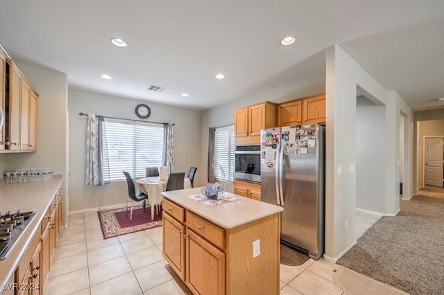 kitchen featuring a kitchen island, appliances with stainless steel finishes, and light tile patterned flooring