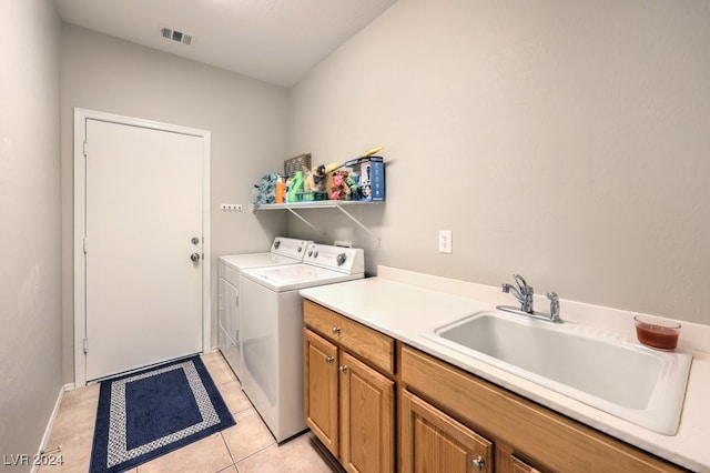 clothes washing area featuring cabinets, washing machine and dryer, sink, and light tile patterned flooring