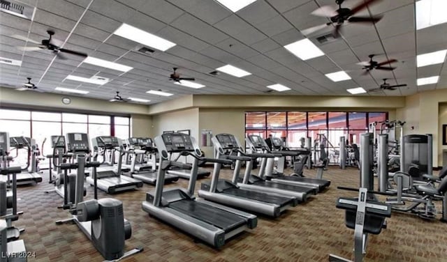 workout area featuring a drop ceiling and dark colored carpet