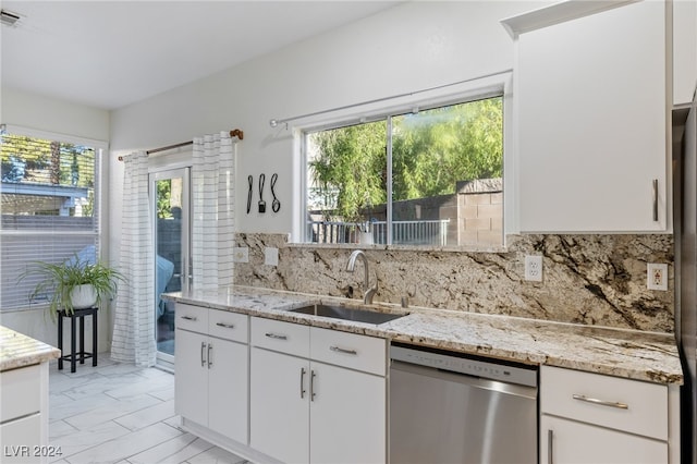 kitchen featuring white cabinets, plenty of natural light, stainless steel dishwasher, and sink