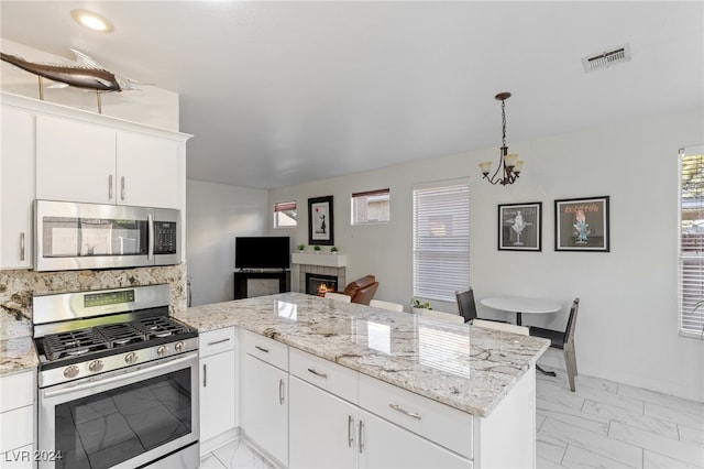 kitchen with kitchen peninsula, white cabinets, and appliances with stainless steel finishes