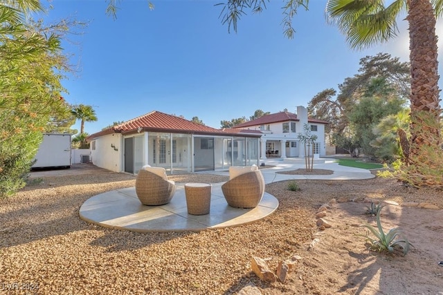 rear view of property featuring a tiled roof and a patio area