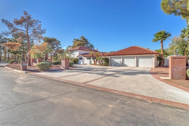 mediterranean / spanish house featuring a garage, driveway, a tile roof, and stucco siding