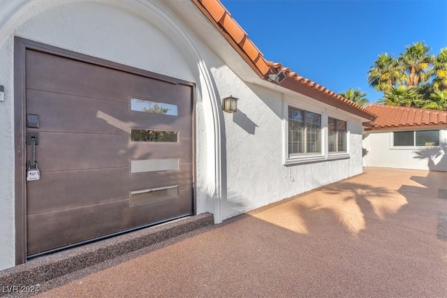 property entrance with a tiled roof and stucco siding