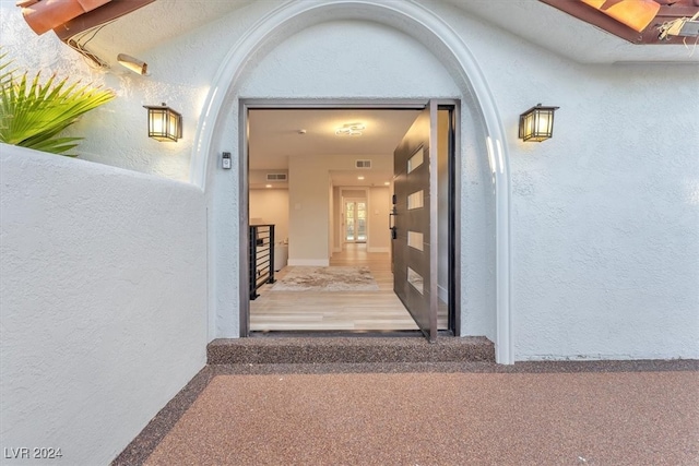 doorway to property with visible vents and stucco siding