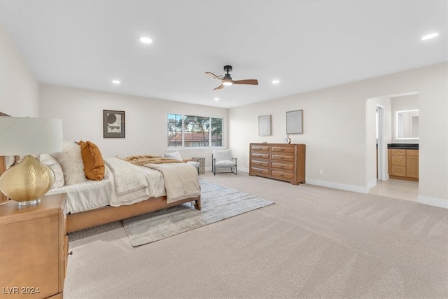 bedroom with ensuite bathroom, recessed lighting, light colored carpet, a ceiling fan, and baseboards