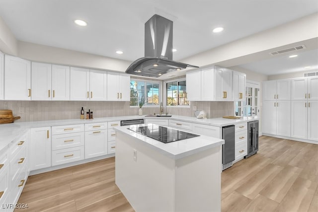 kitchen featuring island range hood, wine cooler, a center island, black electric stovetop, and white cabinetry