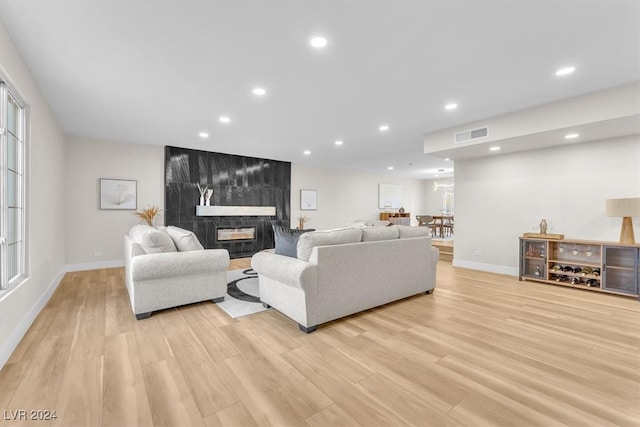 living room featuring light wood-style floors, recessed lighting, and a tile fireplace