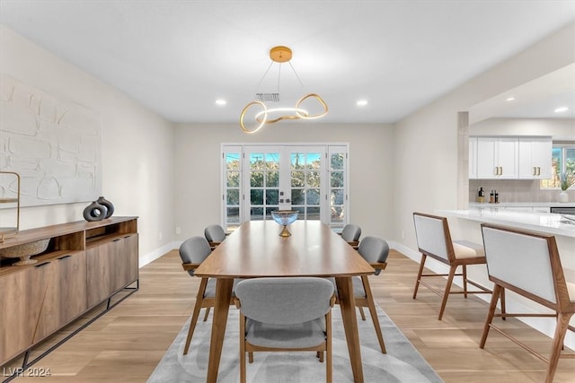 dining area with french doors, visible vents, light wood-style flooring, and baseboards