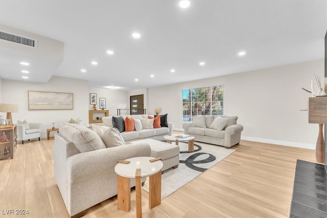 living room with baseboards, light wood-type flooring, visible vents, and recessed lighting