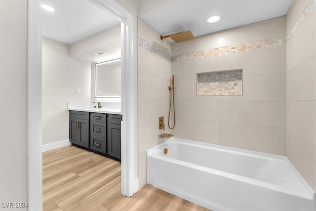 full bath with recessed lighting, a combined bath / shower with rainfall shower, vanity, wood finished floors, and baseboards