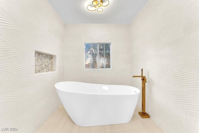 full bath with a freestanding tub and tile walls